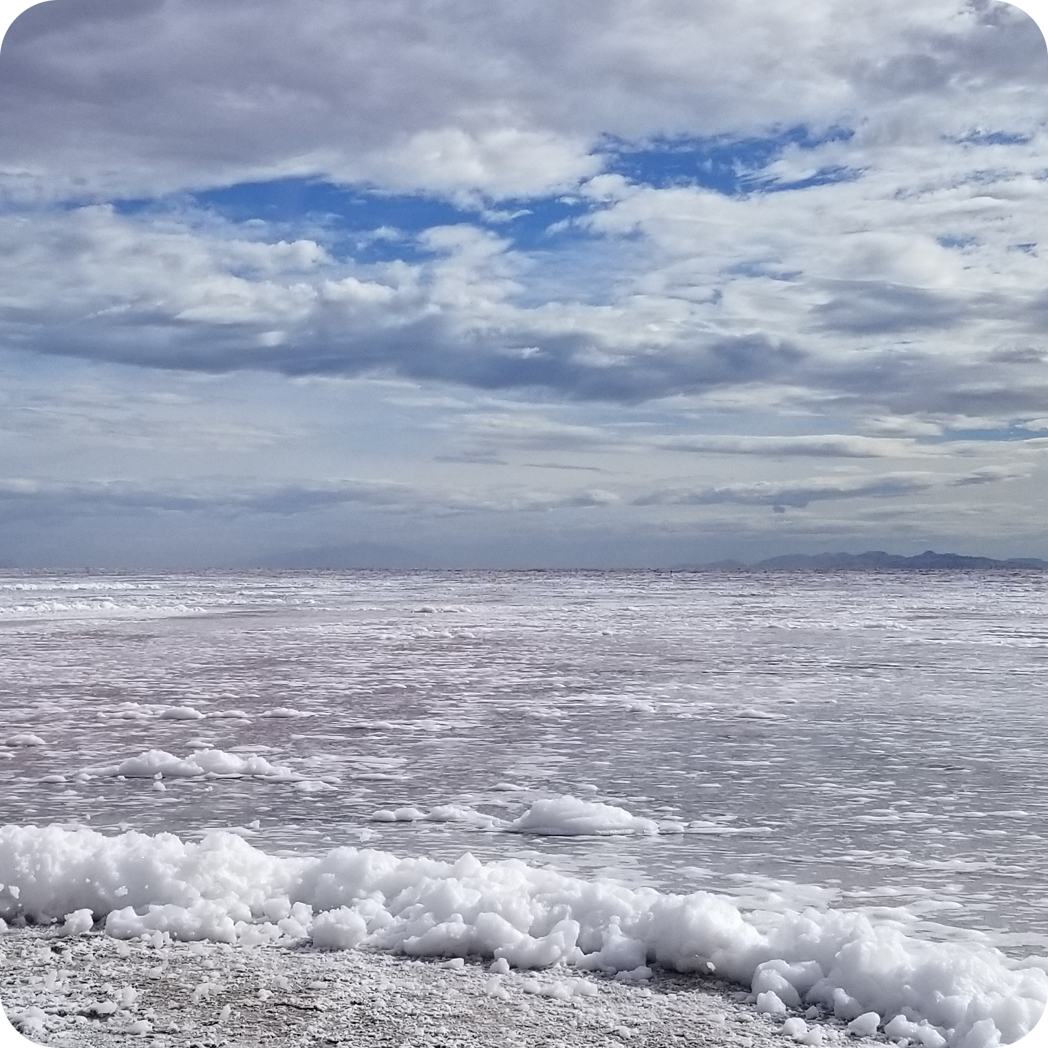 Natural salt flat with mineral-rich shoreline and cloudy sky, source of natural electrolytes