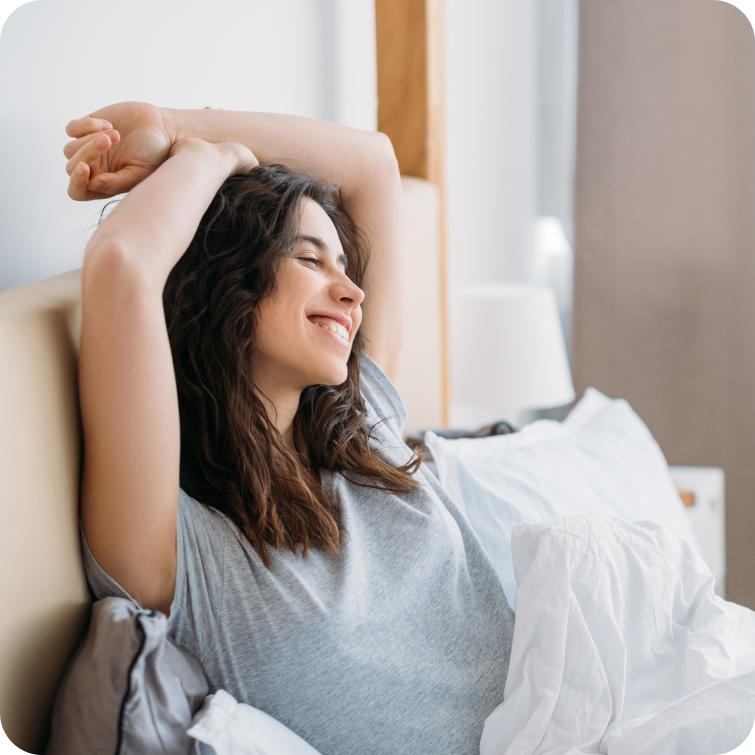 Smiling woman stretching in bed, morning hydration and wellness lifestyle